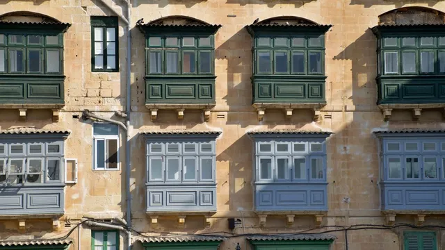 Balcones tradicionales malteses en una fachada de piedra